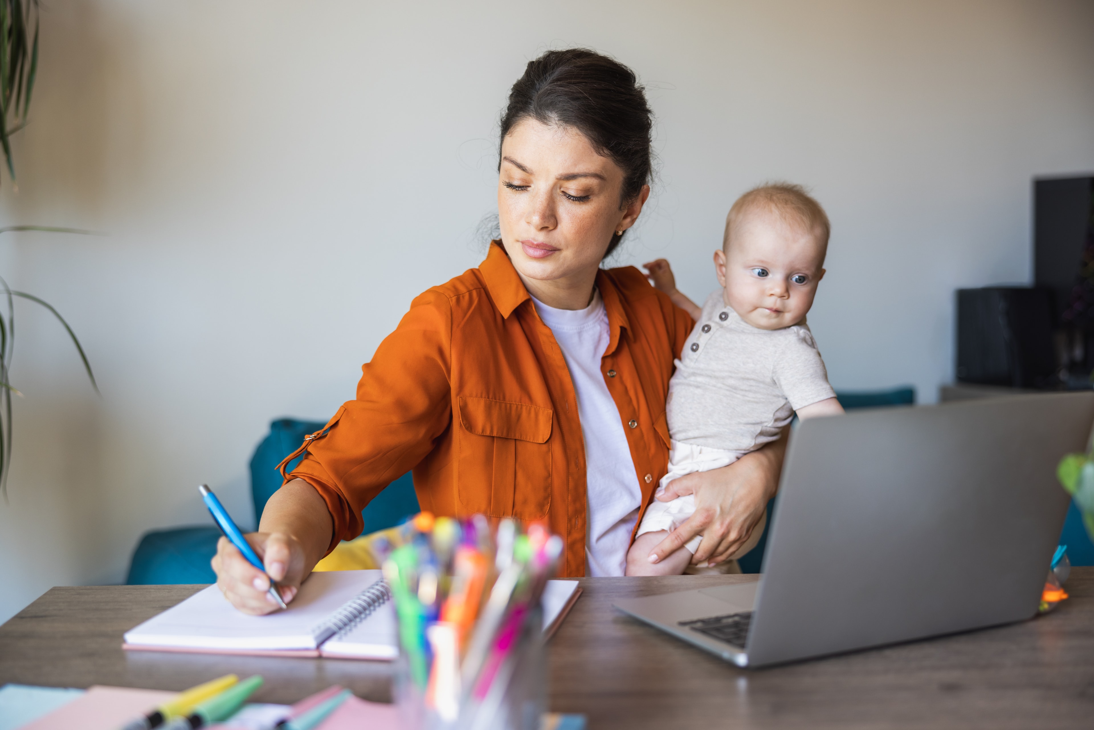 Mutter hält ihr Baby und arbeitet — den eigenen Weg finden